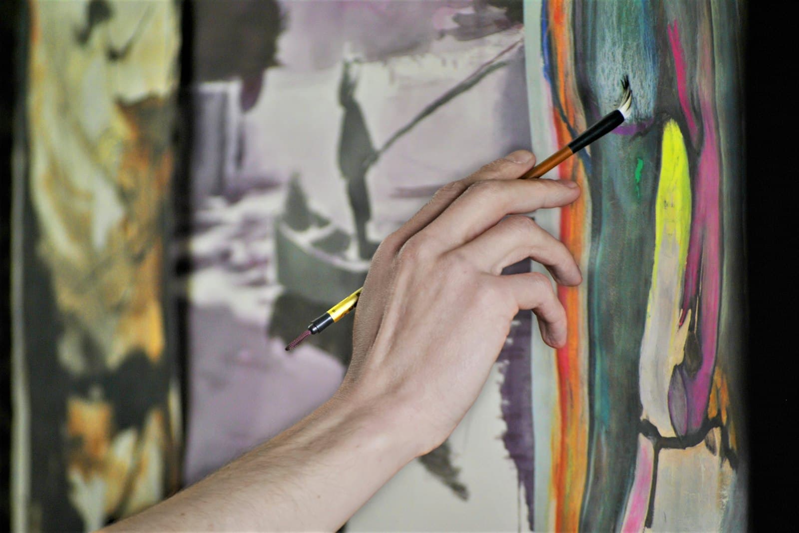 Mãos a pintar uma tela num workshop de arte da Saudade